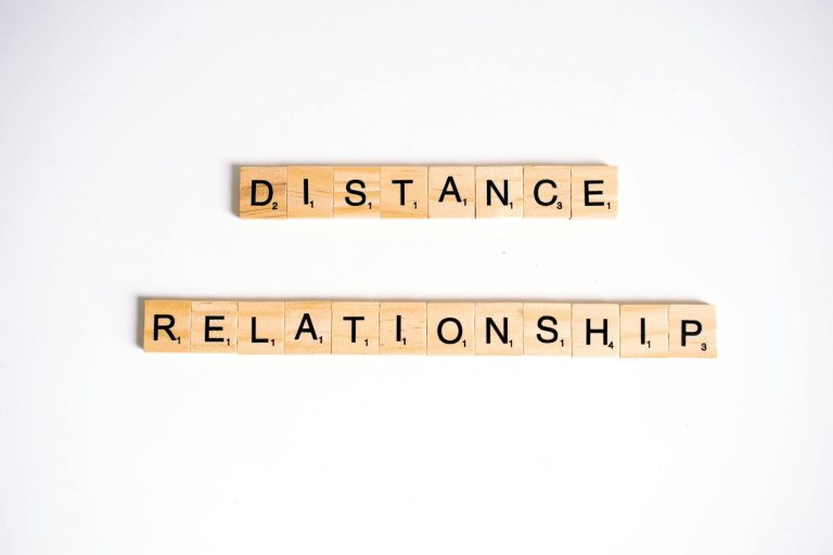 Conceptual image of Scrabble tiles spelling 'Distance Relationship' on a white background.